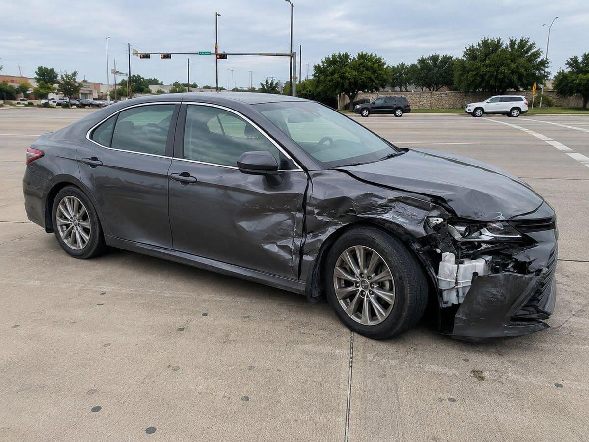 Side view showing crumpled passenger-side fender, door and bumper